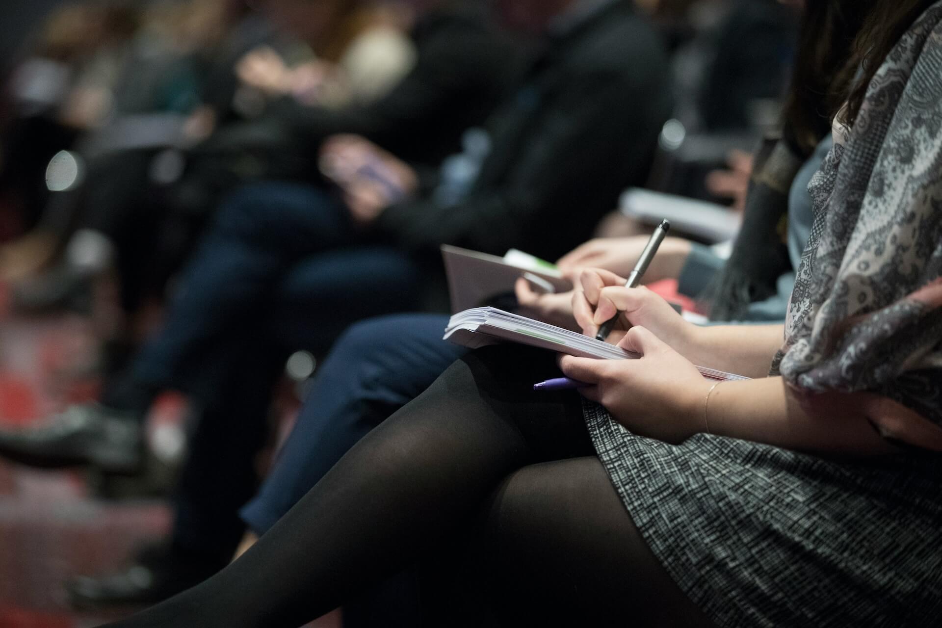 Woman taking notes at a therapist conference